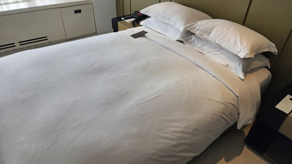 화이트 침구가 깔린 더블 침대